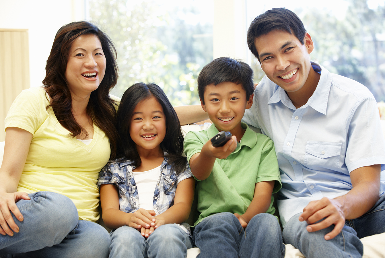 Image of family on couch with TV remote